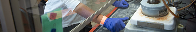 Person working in a machine with a glass protection